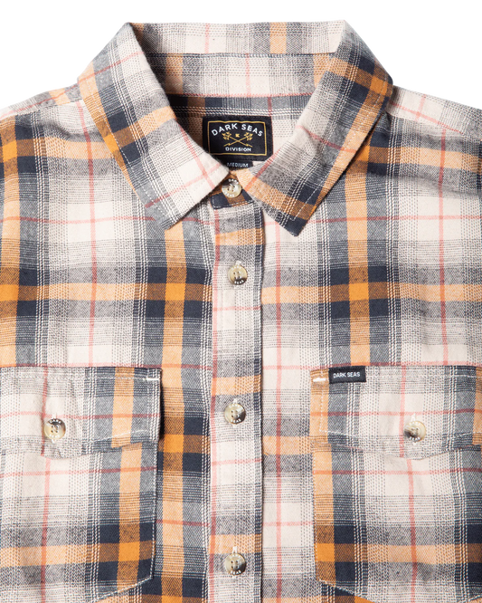 Close-up front view of Dark Seas Arrowhead grey plaid flannel shirt highlighting button placket and flap chest pockets