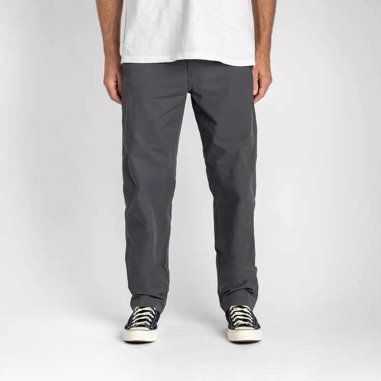 Front view of Roark Layover Pro charcoal men's stretch travel pants with straight leg fit