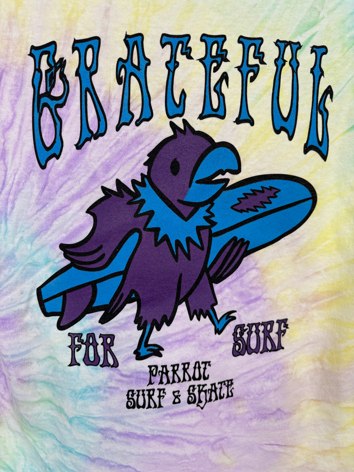 Close-up of Grateful for Surf youth jellybean tie-dye t-shirt back graphic with purple parrot holding blue surfboard