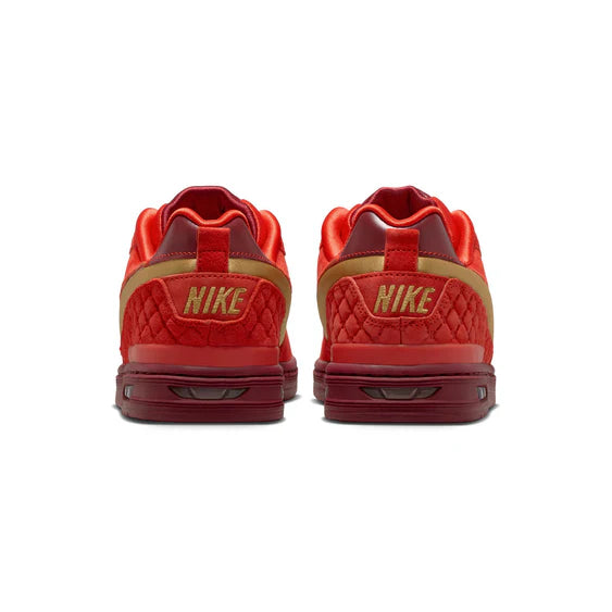 Red Nike sneakers with gold accents on a white background