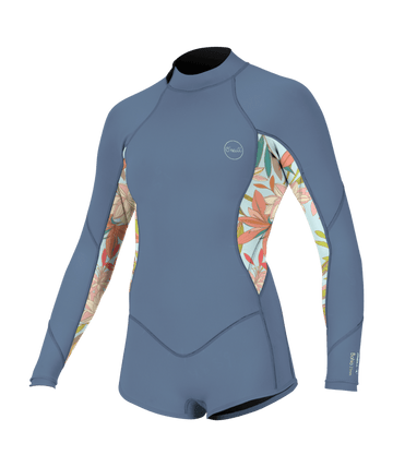 A woman in a wetsuit standing near the shoreline at golden hour, capturing the coastal surf culture featured in Parrot Surf & Skate’s womens wetsuit collection in Mount Pleasant, South Carolina.