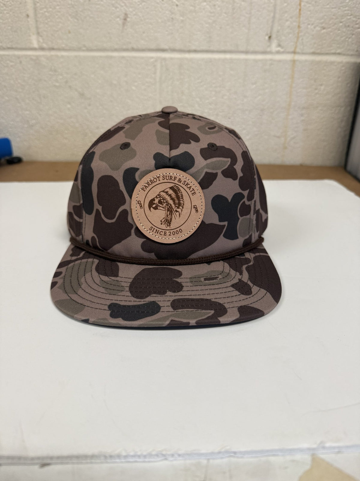 Parrot Surf & Skate 256P Indian Rope hat in Bark Duck Camo with brown rope and leather Indian patch, front view - Parrot gear