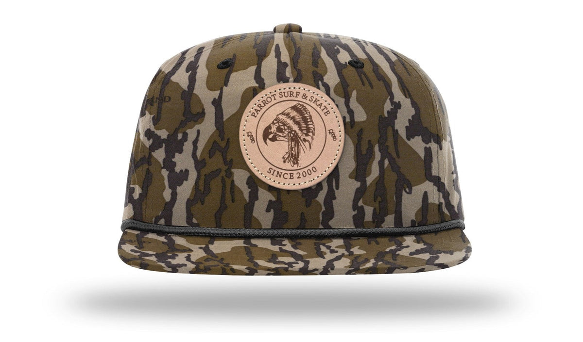 Parrot Surf & Skate 256P Indian Rope hat in Mossy Oak Bottomland with black rope with leather Indian patch, front view - Parrot gear
