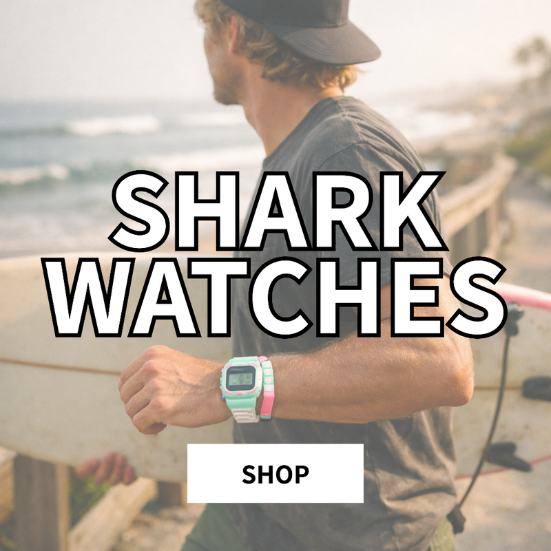 Surfer walking along a coastal boardwalk at golden hour wearing a mint Shark digital surf watch, holding a surfboard near ocean waves at Parrot Surf Shop