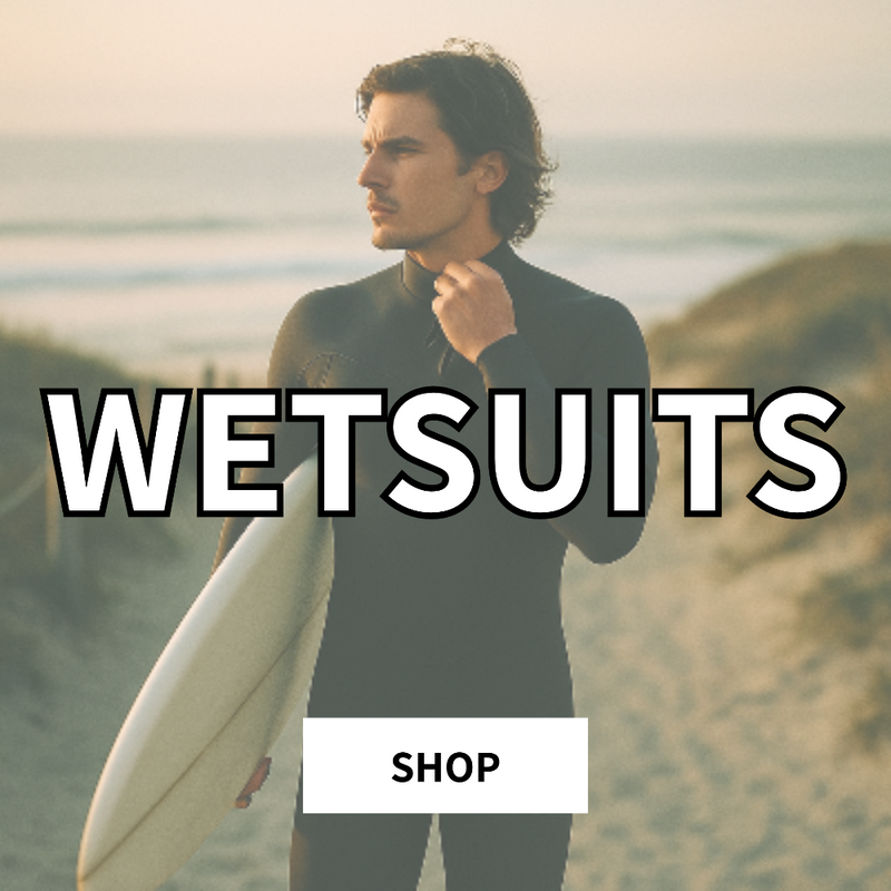Surfer walking out of the ocean in a full wetsuit at golden hour with rolling waves behind, coastal surf scene at Parrot Surf Shop